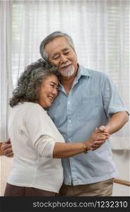 Asian couple Grandparent dancing and hugging together with happy feeling in house, romantic and lover with valentine or anniversary, Long live and Elderly society, Warm family and happiness concept