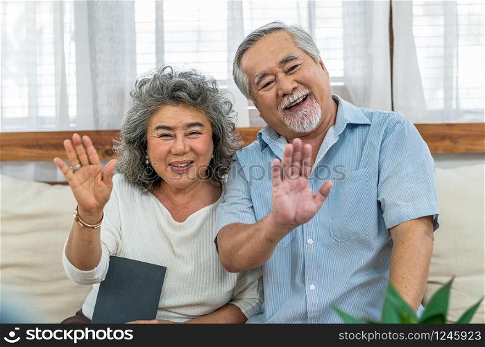Asian couple Grandparent greeting and talking with Granddaughter with happy feeling via video phone call by mobile phone in house, Long live and Elderly society, Warm family and happiness concept