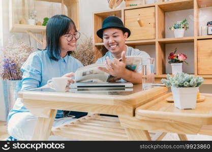 Asian couple reading the magazine over the desk which have technology laptopn in modern workplace or co-working space, freelance and lifestyle or leisure concept