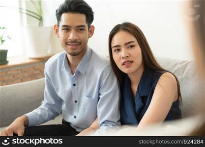 Asian couple sitting on the couch in the psychiatrist room to consult mental health problems by doctor, Health and illness concepts