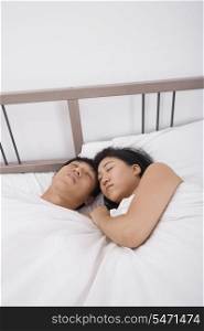 Asian couple sleeping in bed