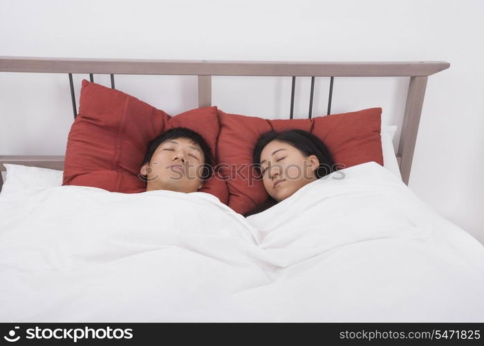 Asian couple sleeping in bed