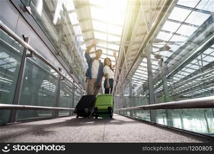 Asian couple traveler with suitcases at the airport. Lover travel and transportation with technology concept.