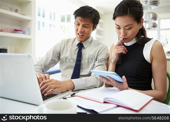 Asian Couple Working From Home Looking At Personal Finances
