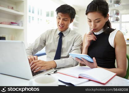 Asian Couple Working From Home Looking At Personal Finances