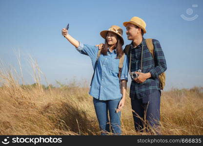 Asian couples are posing together to take photo with smartphone