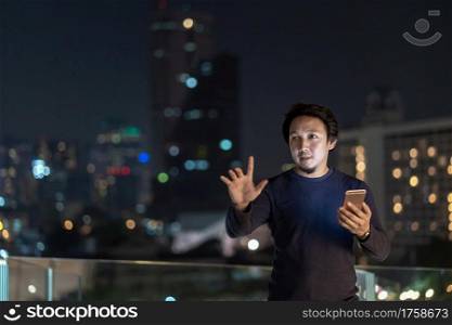 Asian creative freelancer using smart mobile phone with smile action in the financial district area at bangkok river side, Thailand, technology with career concept