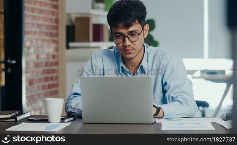 Asian creative man drawing work plan on paper board. Young professional business male think and write information reminder on paper on brick, business situation, startup in Loft office concept.