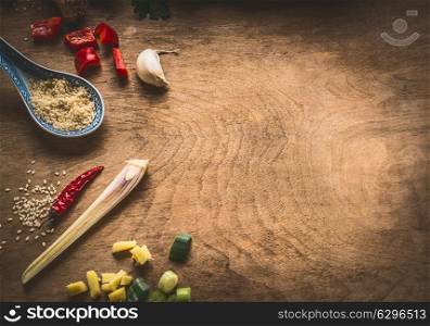 Asian cuisine spices ingredients chopped ginger, chili, sesame seeds, garlic, on rustic wooden background, top view. Chinese or Thai food cooking concept
