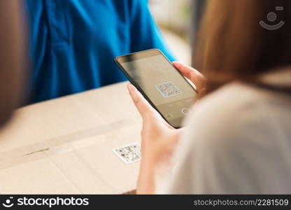 Asian customer young woman using mobile smartphone with QR code payment to receive parcel post box from delivery man, Hands of female scanning at door front house, Online shopping service concepts