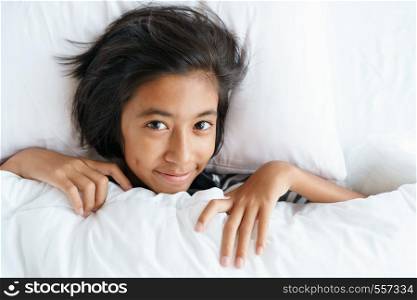 asian cute girl waking from sleep on the morning. Face of little girl are relaxation after wake up.