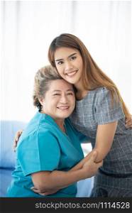 Asian daughter or care assistant helping support senior woman or mother