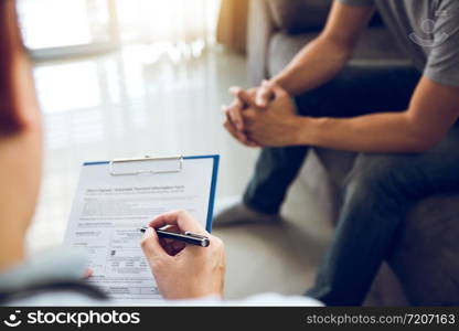 Asian doctor is examining the abnormal items of the body and diagnosing the disease in the paper with the medical report of the patient.