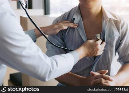 Asian doctor is using a stethoscope listen to the heartbeat of the elderly patient.