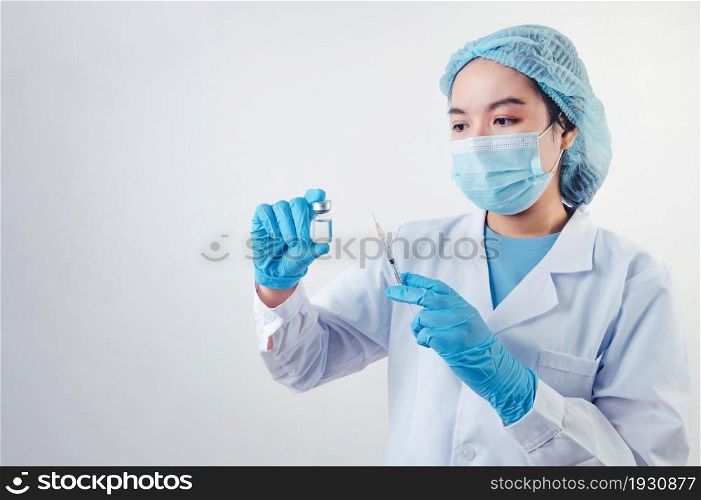 Asian doctor looking and preparing syringe vaccine and vial for injection to illness patient on white background. Medical people and illness prevention technology concept. Coronavirus epidemic theme