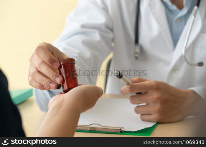 Asian doctor with stethoscope and uniform holding a medicine bottle And is explaining the medicinal properties of the patients. Concept of Medical consultant And medical services