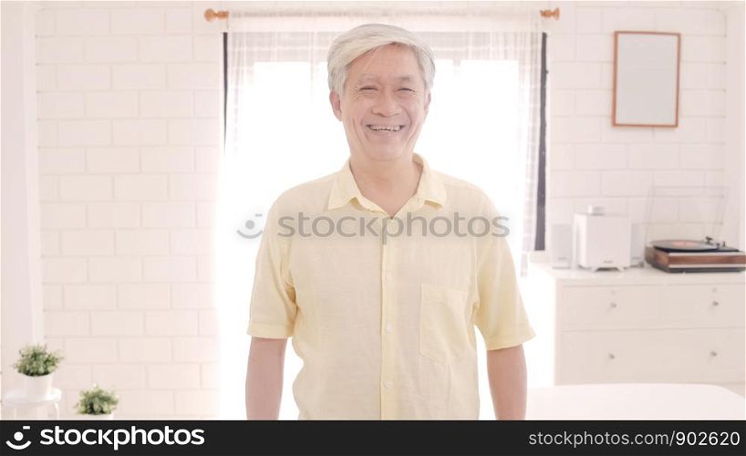 Asian elderly man feeling happy smiling and looking to camera while relax on the sofa in living room at home. Lifestyle senior men at home concept.