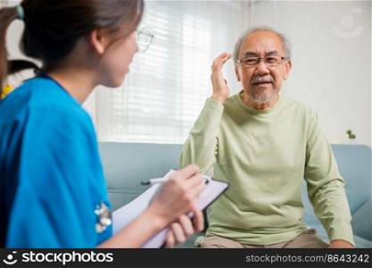 Asian elderly man patient have headache and female nurse talking, checking up and recording current symptoms on clipboard in living room, Home healthcare and medical service