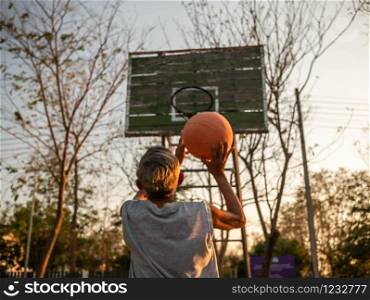 Asian elderly men playing basketball on playground on summer day. Healthy lifestyle and Healthcare concept.