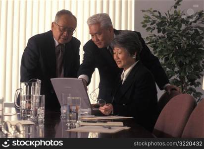 Asian Executives Looking At Laptop Computer