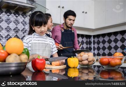 Asian families are cooking and parents are teaching their daughters to cook in the kitchen at home. Family activities on holidays and Happy in recreation concept