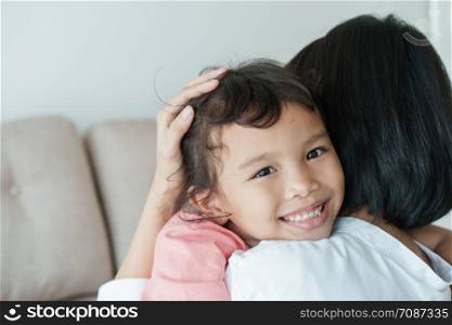 Asian families with daughters and mothers are embracing each other with love. Asian girl with a smile on her face is in the mother?s arms. Family with mother and girl who have shown love to each other by embracing