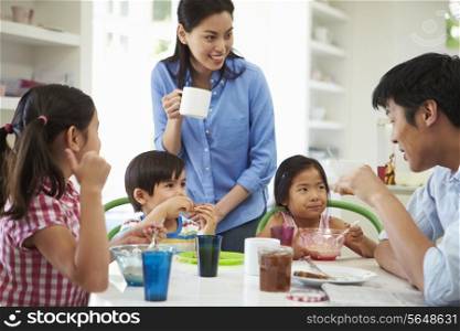 Asian Family Having Breakfast Together In Kitchen
