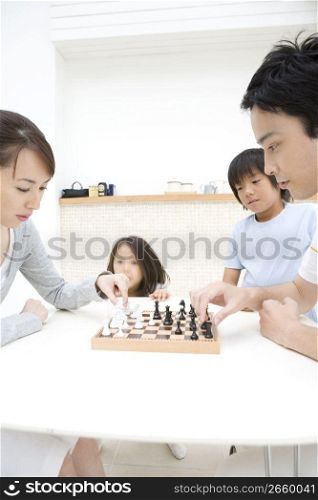 Asian family playing chess