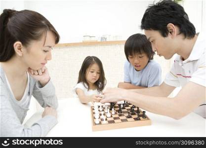 Asian family playing chess