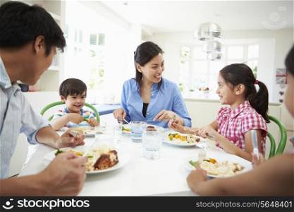 Asian Family Sitting At Table Eating Meal Together