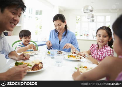 Asian Family Sitting At Table Eating Meal Together