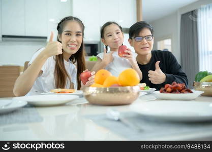 Asian family They are having breakfast together happily in the dining room of the house.