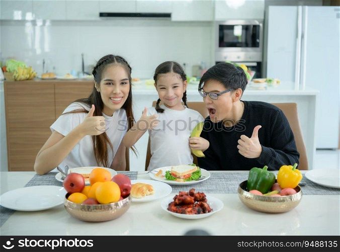 Asian family They are having breakfast together happily in the dining room of the house.