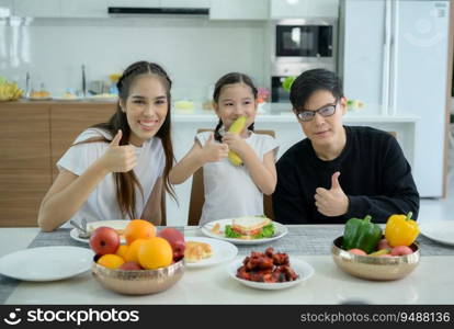 Asian family They are having breakfast together happily in the dining room of the house.