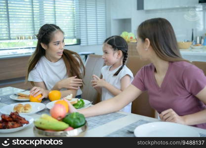 Asian family They are having breakfast together happily in the dining room of the house.