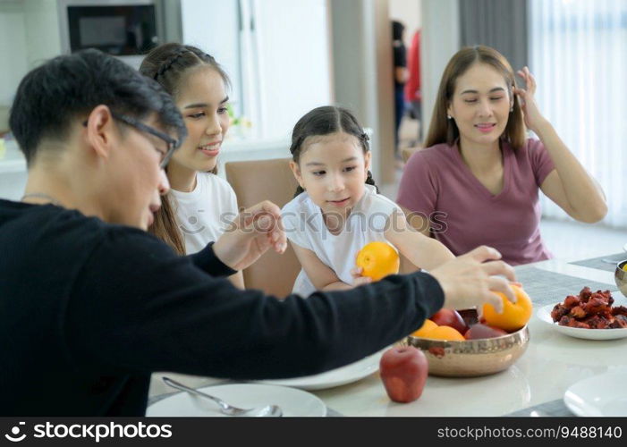 Asian family They are having breakfast together happily in the dining room of the house.