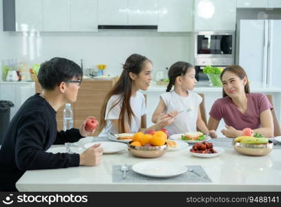 Asian family They are having breakfast together happily in the dining room of the house.