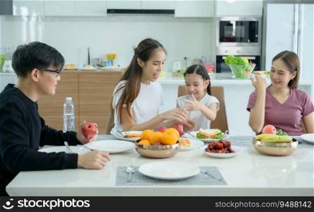 Asian family They are having breakfast together happily in the dining room of the house.