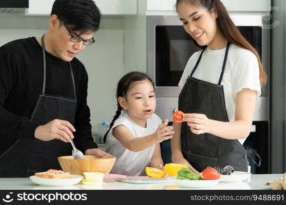 Asian family They are having cooking together happily in the kitchen room of the house.