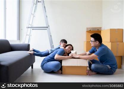 Asian family unpacking cardboard boxes at new home, Relocating for new real estate property concept