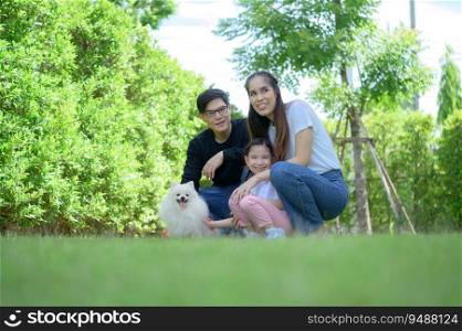 Asian family with both father, mother and daughter having fun in the garden of the house happily
