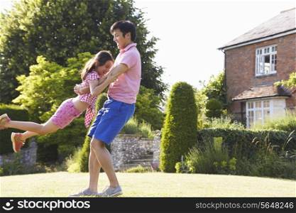 Asian Father And Daughter Playing In Summer Garden Together