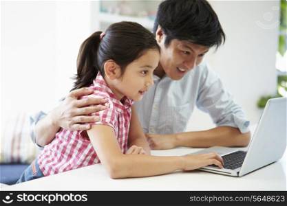 Asian Father Helping Daughter To Use Laptop At Home