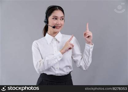 Asian female call center operator with smile face advertises job opportunity, wearing a formal suit and headset pointing finger for product on customizable isolated background. Enthusiastic. Asian operator wearing formal suit and headset with pointing finger Enthusiastic