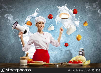 Asian female cook holding megaphone. Asian female cook holding megaphone vegetables flying in air