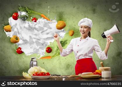 Asian female cook holding megaphone. Asian female cook holding megaphone vegetables flying in air