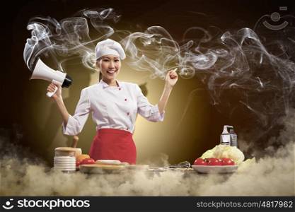 Asian female cook holding megaphone. Asian female young cook smiling holding megaphone