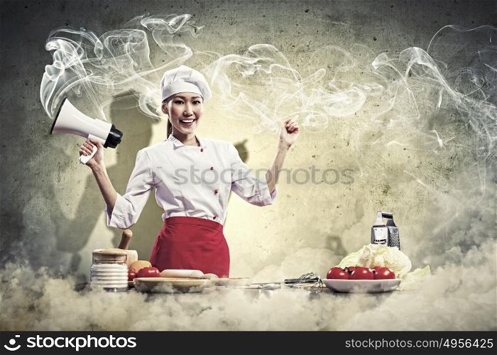 Asian female cook holding megaphone. Asian female young cook smiling holding megaphone