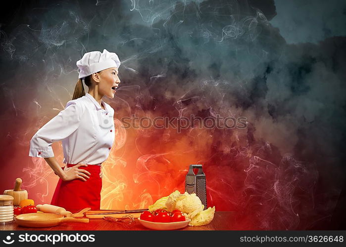 Asian female cook in anger against color background with shine effects