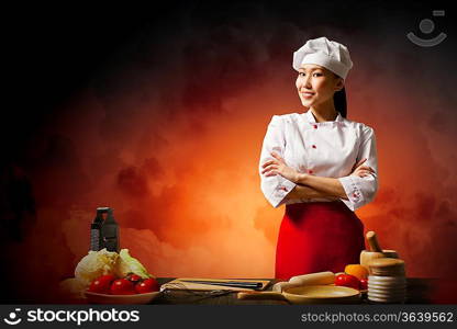 Asian female cook in anger against color background with shine effects